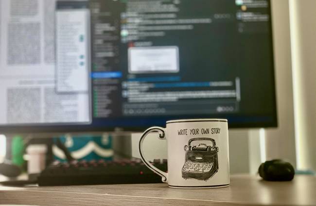 A modern workspace with a laptop displaying well-formatted CSS code, papers, and a coffee mug—symbolizing clean, organized coding for web development