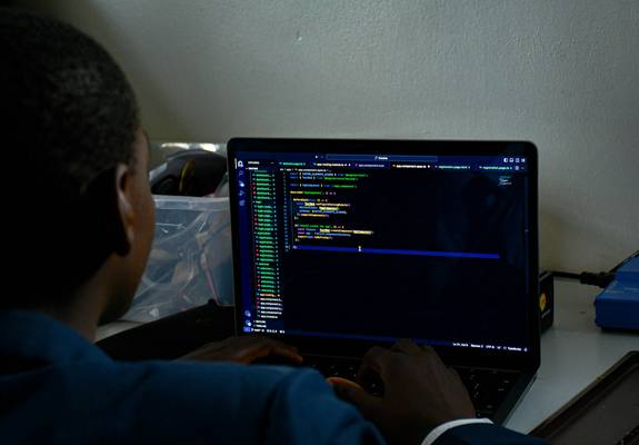 A web developer working on a laptop with CSS code visible, representing website optimization and minification