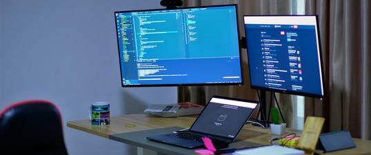 A modern workspace with a developer validating CSS code on a laptop, showing errors and suggestions