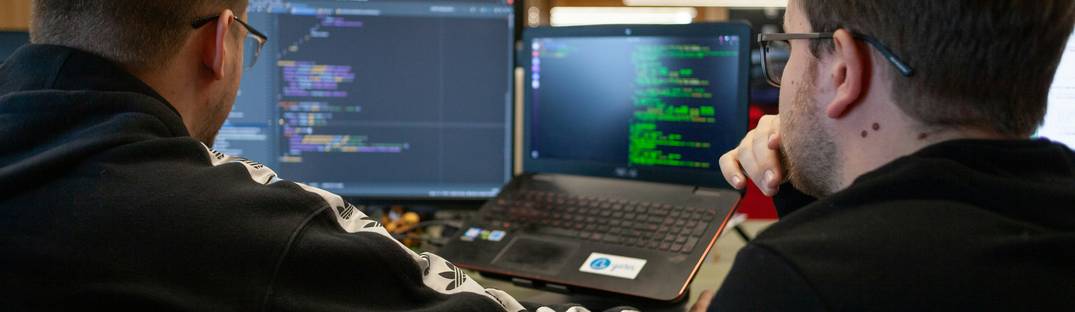 A conceptual photo of developers collaborating at computers, transforming data between XML and JSON formats