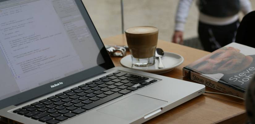 A professional reviewing email best practices on a laptop and smartphone, with inbox and analytics visible