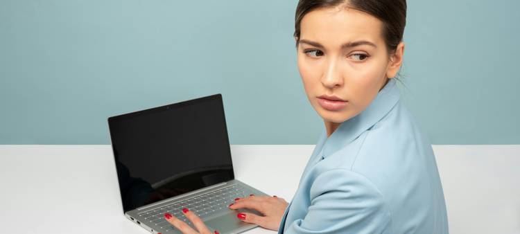 Business professional reviewing emails on a laptop in a modern office, symbolizing email compliance and security
