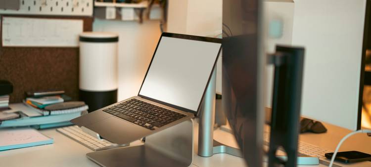 A professional workspace with a laptop displaying an email signature installation screen