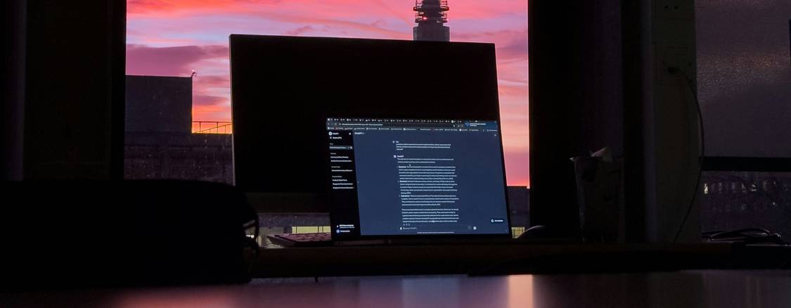 A developer working at a computer, digital clock and sunrise landscape visible, illustrating time and programming