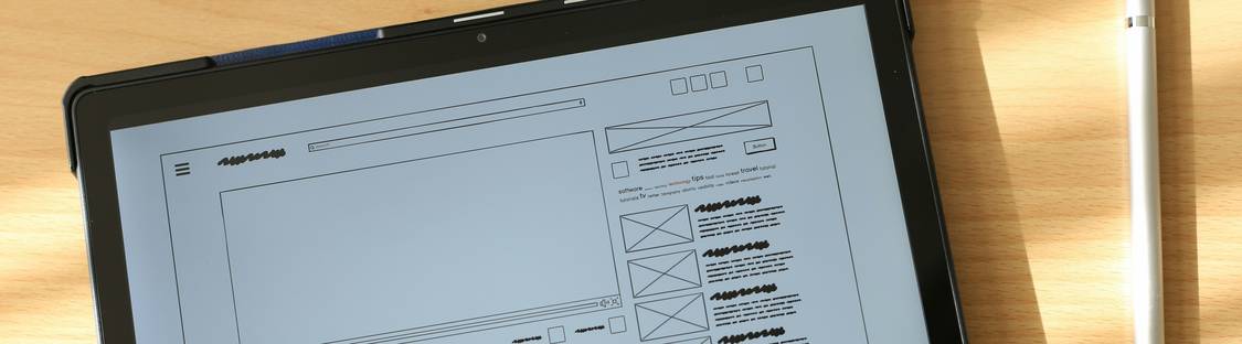 A modern workspace showing a designer previewing a responsive HTML email on both a laptop and smartphone