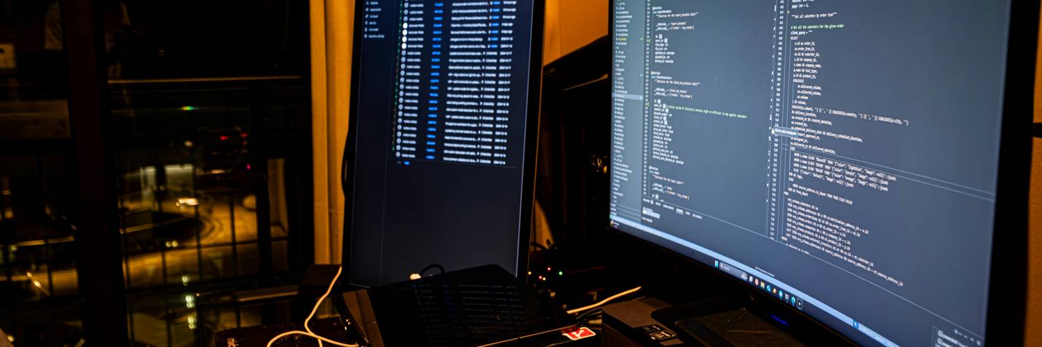 A web developer comparing HTML minification vs obfuscation in web development on a large monitor