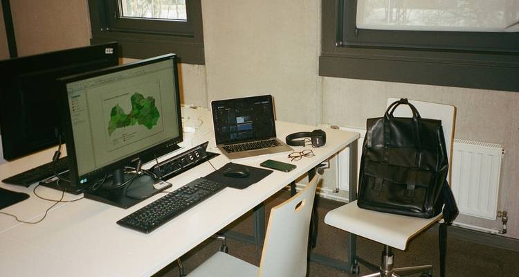 Modern workspace with a laptop and design wireframes showing placeholder text for content planning