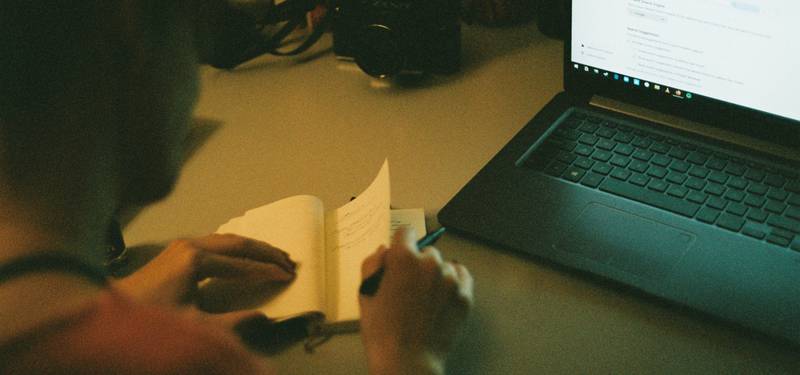 A person writing on a laptop with markdown code visible on the screen, for documentation or blogging
