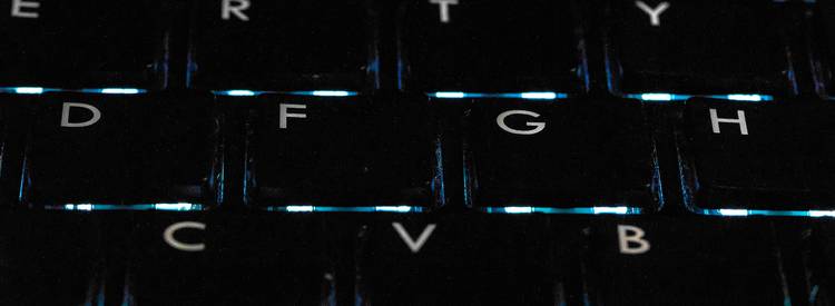 A technology-themed photo featuring binary and octal code on a computer screen, with a programmer at work