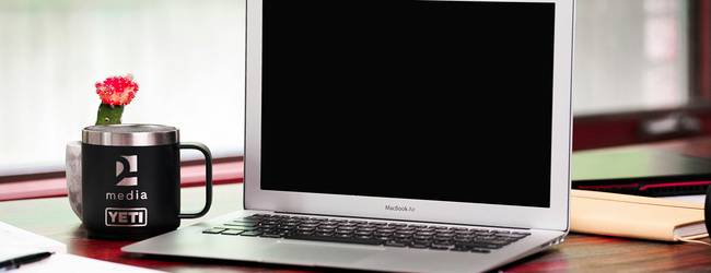 A digital workspace with a laptop and contract on screen, symbolizing online terms and agreements