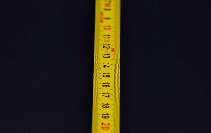 A variety of measuring tools and units, like rulers, scales, beakers, and thermometers, representing global measurement systems